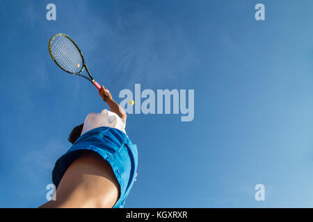 Professional player doing a tennis kick on court in the afternoon. Stock Photo