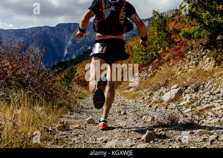 back man athlete runner running on mountain trail during Crimea Х Run Stock Photo