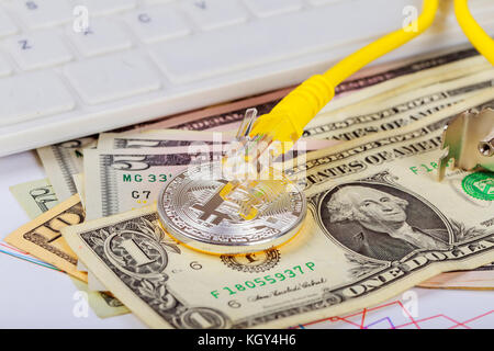 The coin of bitcoin lies on dollars against the background of the video card. coin bitcoin dollars graphic card internet wire Stock Photo