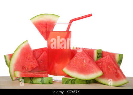 Glass of watermelon lemonade on a wood table surrounded by fruit. Red straw, slice of watermelon on side of cup, isolated on white background. Stock Photo