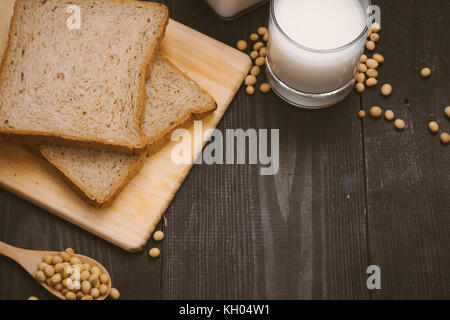 Breakfast with soy beans in spoon, soy milk and sandwich on wooden background Stock Photo