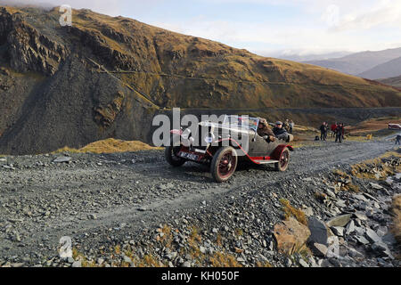 Vintage cars take part in the annual Lakeland Trials vintage car rally as they drive along the quarry road at Honister Slate Mine, in Borrowdale, Keswick, Cumbria. Stock Photo