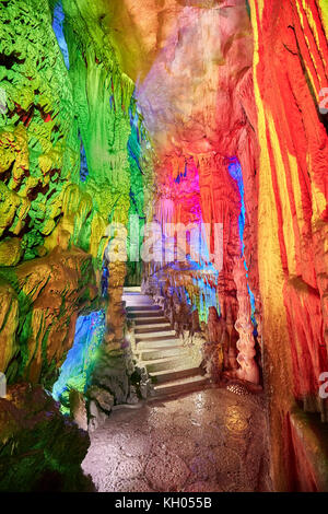 Stone stairs in Reed Flute Cave, natural limestone cave with multicolored lighting in Guilin, Guangxi, China. Stock Photo