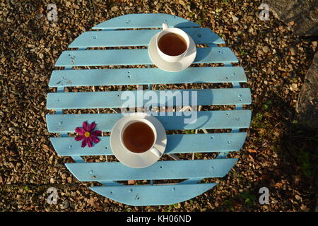 garden table and two cups of tea with flower Stock Photo