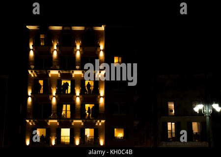 Corfu, Greece - April 15, 2017: Holly Saturday before the Resurrection in Corfu.People on their balconies shot in high dark contrast and grain to add Stock Photo