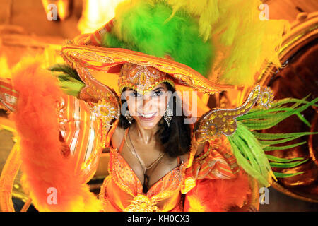 A smiling samba dancer from samba school Grande Rio is dressed in a carnival costume and dances down the Parading Avenue at the Sambodromo. Brazil 03.03.2014. Stock Photo