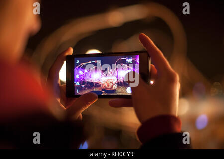 A festival visitor is taking a photo with her smart phone at the Lumiere Light Festival 2013 in Derry-Londonderry. UK 29/11/2013. Stock Photo