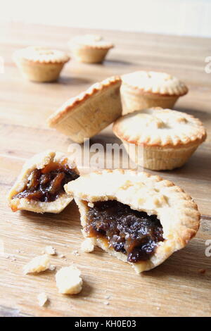 Selection of several mince pies, some broken open or partly eaten. A traditional festive Christmas dessert or pudding. Stock Photo