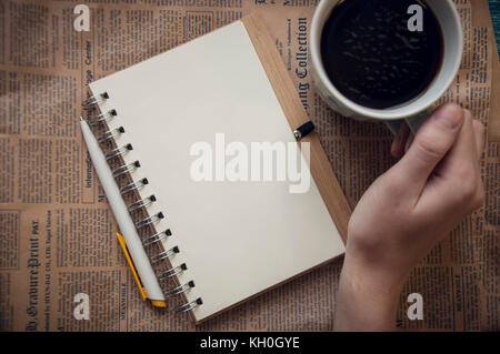 blank notebook with hands, pen and cofee on brown Stock Photo