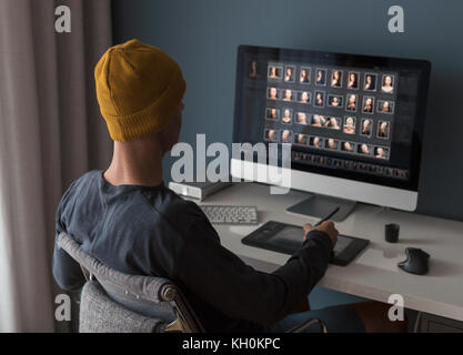 Man working at home editing pictures on computer Stock Photo