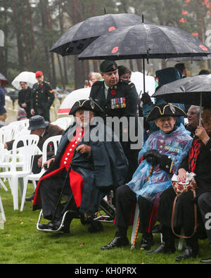 Two Chelsea Pensioners wait in the rain for the start of the Canadian Service of Remembrance at Brookwood CWGC Cemetery in Surrey on Armistice Day Stock Photo