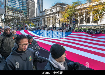 New York, USA, 11 Nov 2017.  Ground Zero volunteers carry a huge US flag through New York's Fifth Avenue in front of the NY Public Library during the 2017 Veterans Day parade . Photo by Enrique Shore/Alamy Live News Stock Photo