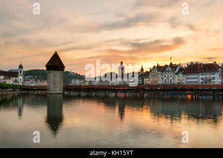 Dramatic sunset over the old town of Lucerne, Chapel Bridge and Water tower in Lucerne, Switzerland. Stock Photo