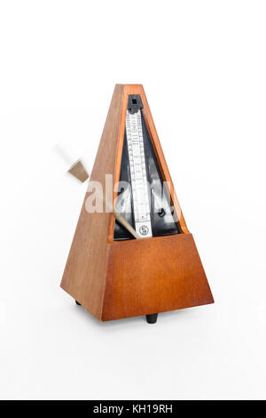 A traditional wooden clockwork Maelzel pyramid metronome against a white background, 1970s Stock Photo