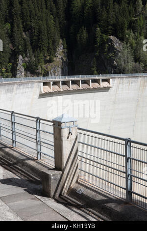 GIBIDUM DAM, NATERS, SWITZERLAND - September 22, 2017: View from on top of a hydroelectric power dam with its spillways and iron safety fence. Stock Photo