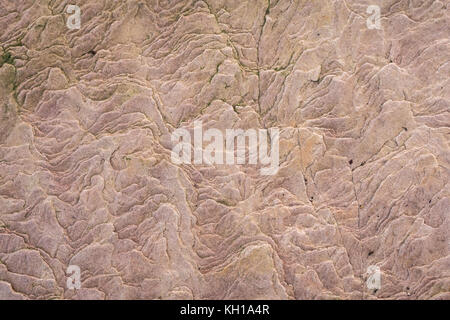 Close up of wavy patterns in sedimentary pink sandstone on rocky shoreline, Scotland, United Kingdom Stock Photo