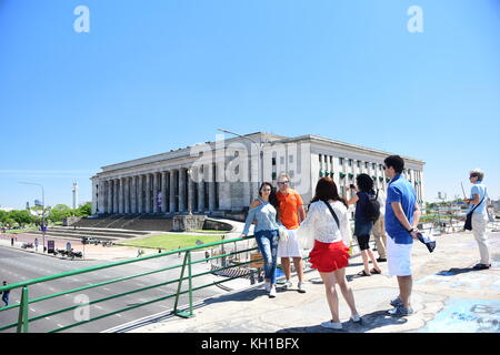 Tourists pose for picture while standing on a bridge in front of University of Buenos Aires Law School building. Stock Photo