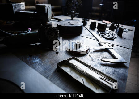 Welder workshop.Professional trammel ruler,electric grinder machine on table in work room at factory.Welder tools for metalwork manufacturing.steel cr Stock Photo