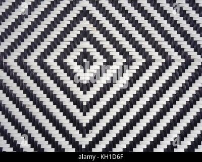 A black and white diamond pattern formed in woven plastic as a background Stock Photo