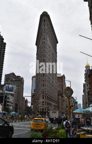 Yellow cab and cast iron clock in front of the Flatiron Building, New York City. Stock Photo