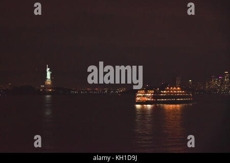 Statue of Liberty and Staten Island Ferry at night, New York City Stock Photo