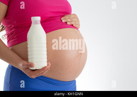 Pregnancy and healthy menu - pregnant woman with milk bottle isolated on white background Stock Photo