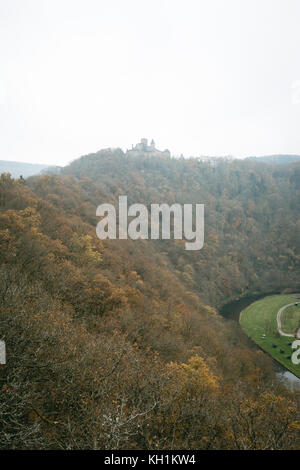 Bourscheid castle in the fog. Old fortress on a hill in Luxembourg. Autumn colors. Stock Photo