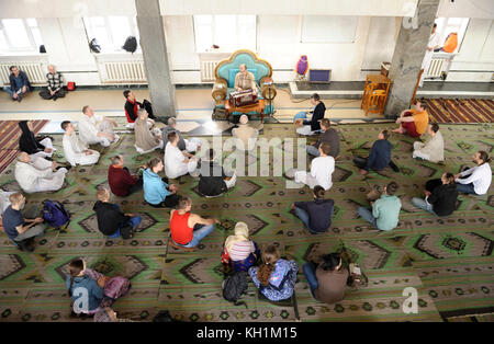 Krishna parishioners sitting on a floor and listening to guru in a temple. April 3, 2017. The Krishna temple, Kiyv, Ukraine Stock Photo