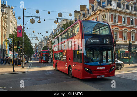 A red double decker bus in London's West End travels down Oxford Street. London buses are a great way to travel around the city. Stock Photo