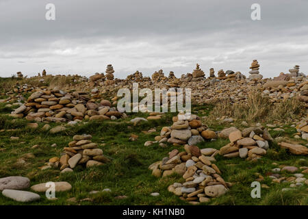 Man made stacks of stone / cairns - lining the east beach of Holy Island Stock Photo