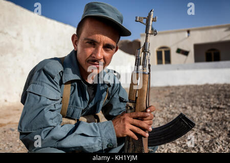 Afghan National policeman with AK47 rifle on guard at a school in nowzad, helmand province, afghanistan Stock Photo