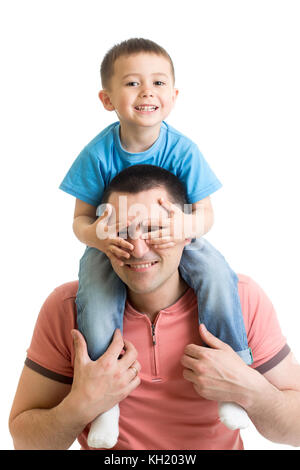 Child closes hands eyes father. Happy little boy enjoying with riding on father's back. Happy family portrait. Laughing dad with kid isolated on white background. Stock Photo