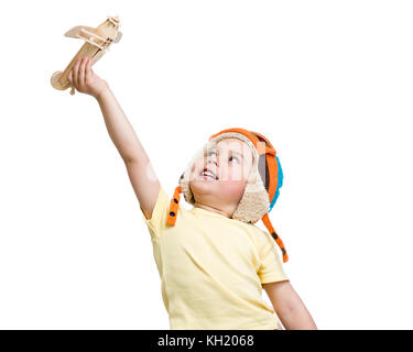 Happy kid boy in helmet pilot plays with wooden toy airplane. Isolated on white background. Stock Photo