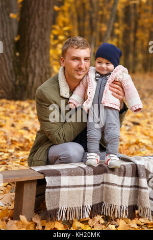 young father with a little daughter in autumn park. Happy family, paternal love, autumn season, outdoors concept Stock Photo
