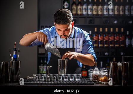 Expert barman is making cocktail at night club Stock Photo