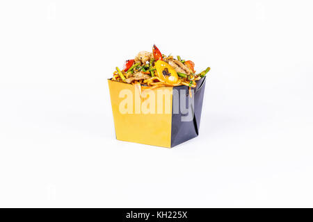 Chinese food. Stir fry noodles with chicken on white background. In take away wok noodles box. Stock Photo