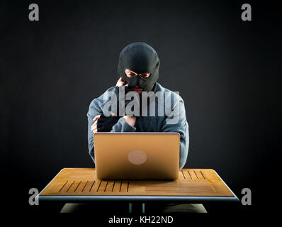 Hacker thinks how he will crack the laptop Stock Photo