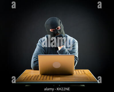 Hackers do not get to crack the laptop. He chews his fist in frustration Stock Photo