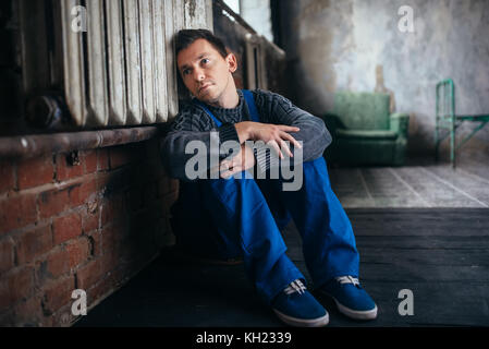 Depressed man sitting on the floor, psycho patient Stock Photo