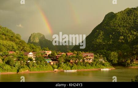 Rainbows above Nong Khiaw, Laos, in the early evening light Stock Photo