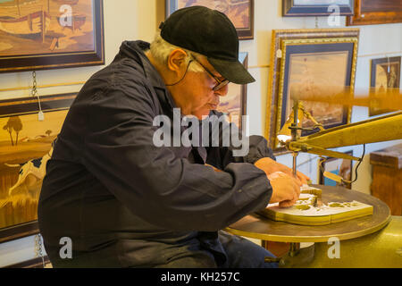 A skilled woodworker cuts an intricate design into a piece of wood in Sorrento, Italy Stock Photo