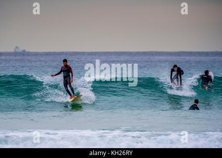 Multiple surfers ride a wave at Sydney's iconic Bondi Beach, NSW, Australia Stock Photo