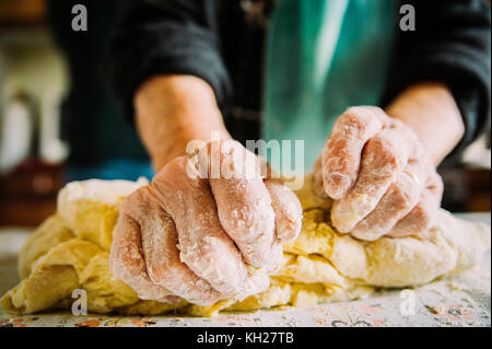 wrinkled hands making pasta for bread in traditional way Stock Photo