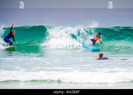 Multiple surfers ride a wave at Sydney's iconic Bondi Beach, NSW, Australia Stock Photo