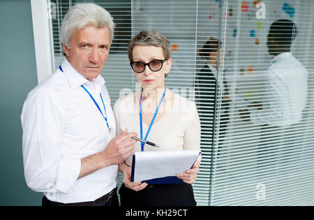 Serious inspectors reading papers with working data in office Stock Photo