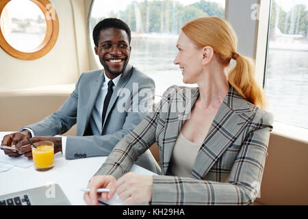 Two colleagues in formalwear taking at break after meeting on steamer Stock Photo