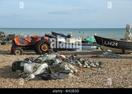 Open fishing boats pulled up on the shingle of Bognor beach, west Sussex, UK. Shows nets and lobster pots piled in foreground Stock Photo