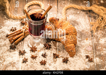 Winter drink. Hot mulled wine and croissants on a table Stock Photo