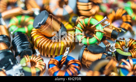 Colorful coils with magnetic core and copper winding. Background from inductors. Small depth of sharpness. Research, development, science, technology. Stock Photo