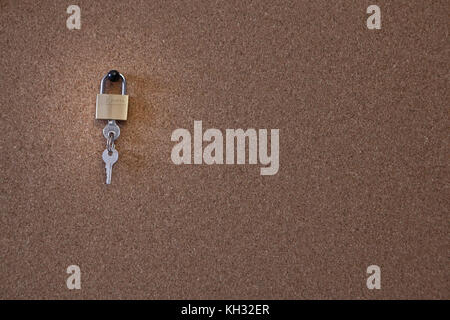 lock hanging on cork board Stock Photo
